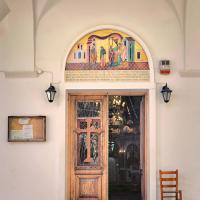 Doorway decorated with a wooden cross and colorful painting of four figures